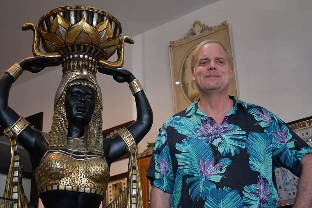 Pismo Beach Coins Etc Gallery owner John Zalesny next to life-size Nubian Princess statue