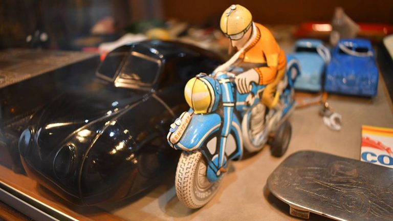 Collectibles vintage tin toy motorcycle rider and sportscar at Pismo Beach Coins Etc Gallery